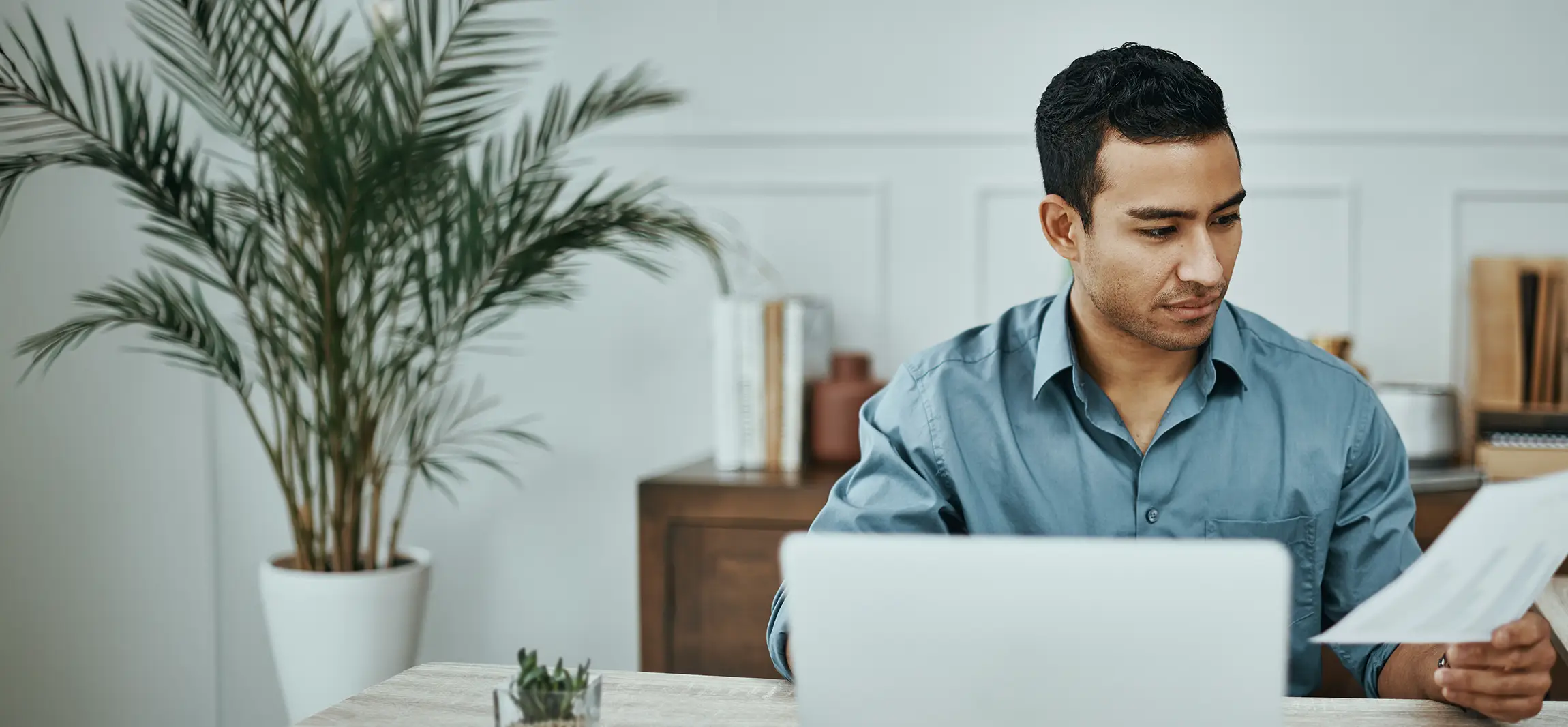 A social worker reviewing his hand written notes at his desk.