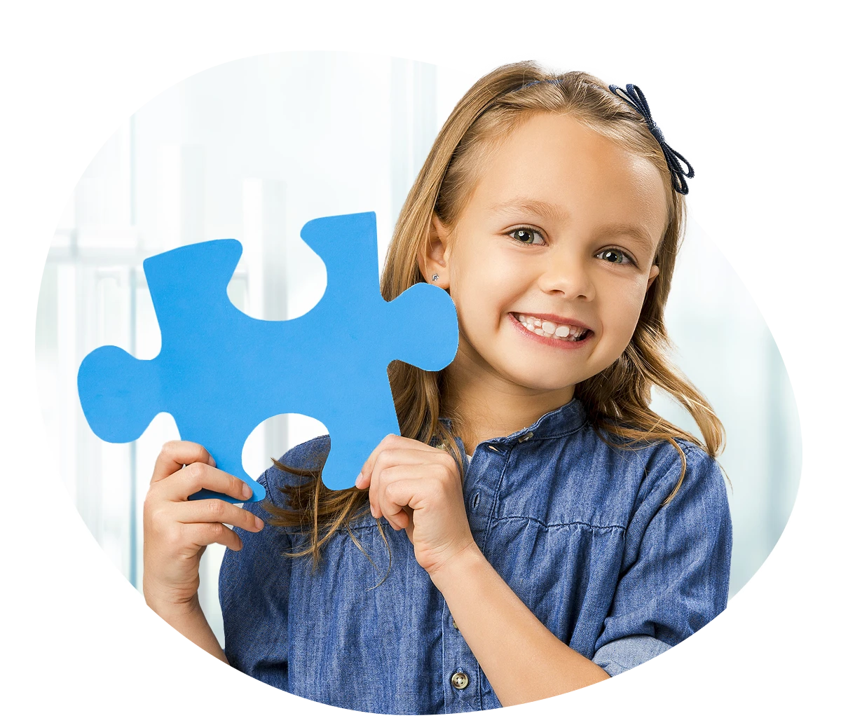 Little girl holding up a puzzle peice