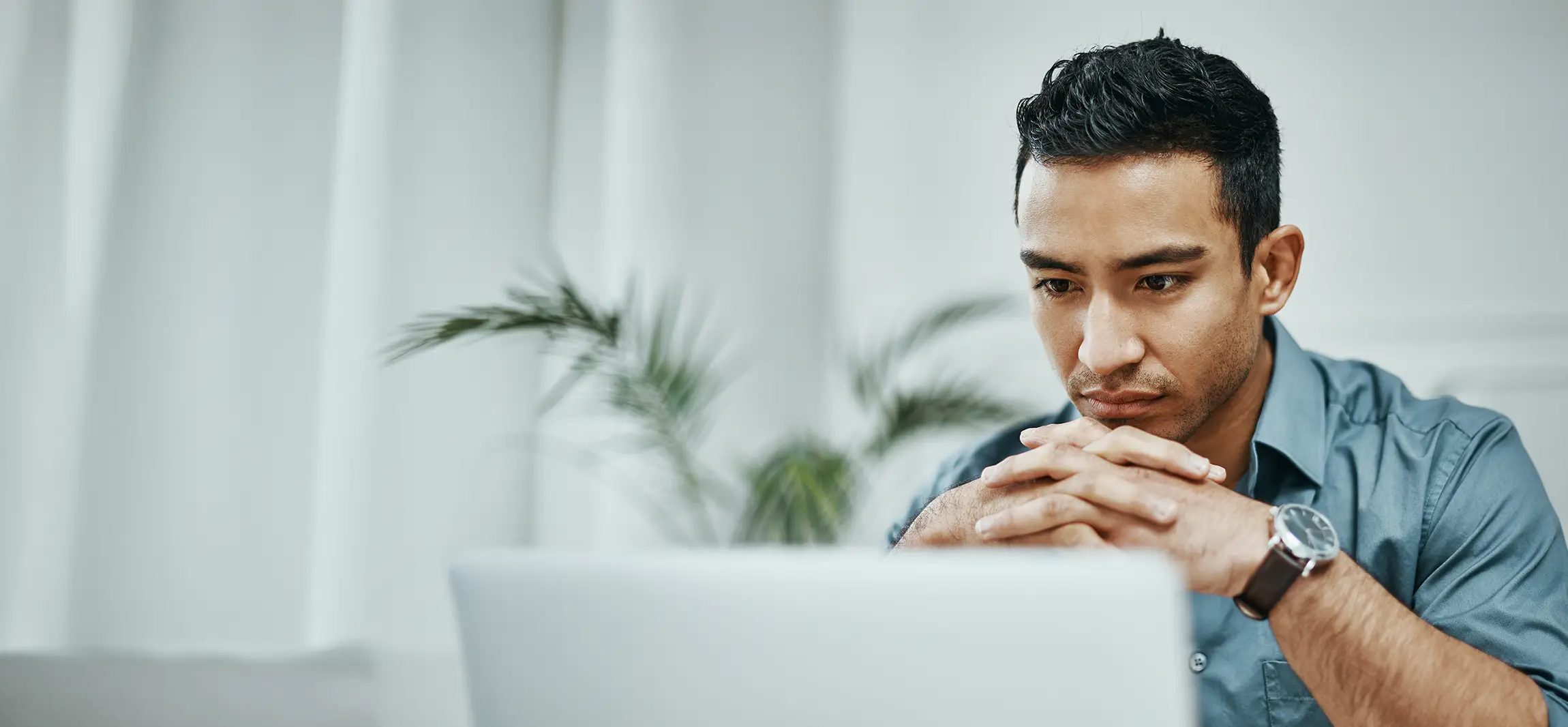 A social worker working hard at work, starring at his computer screen.