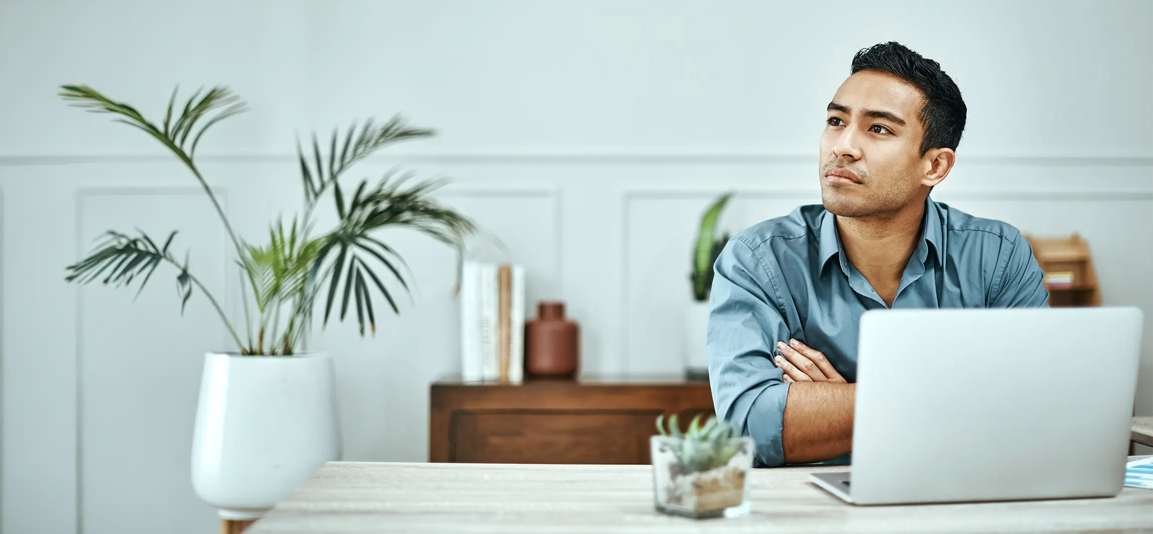 A social worker working at his desk, taking a break and coniplating his next task.