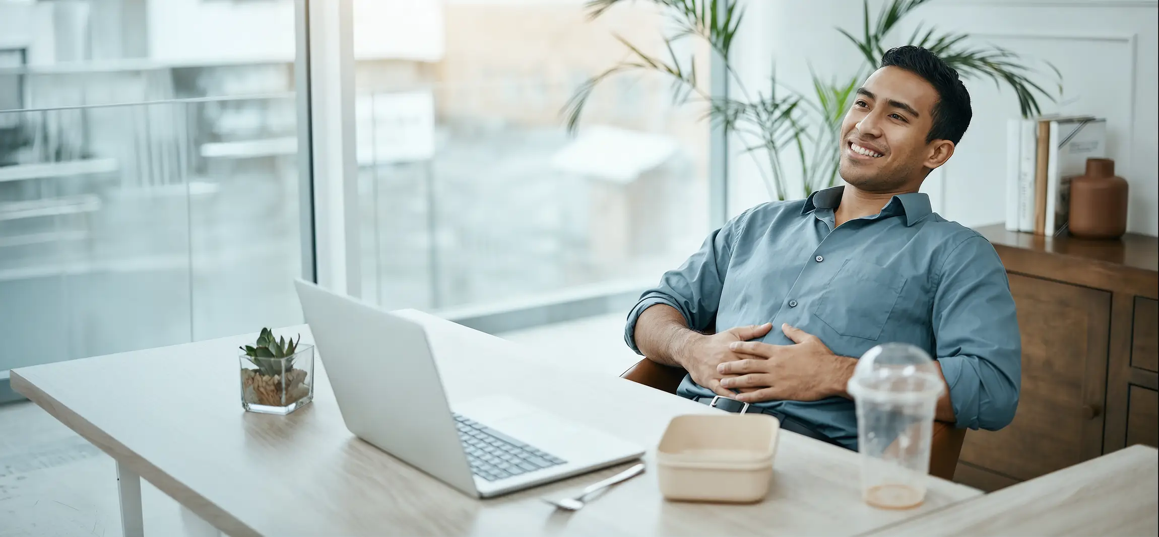 A social worker working at his desk, taking a break with a full belly from his lunch. Ready to get back into his work.