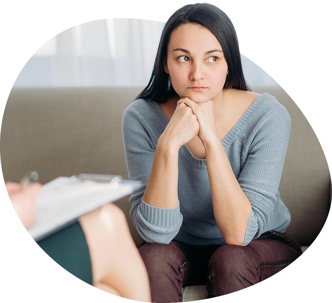 A woman in a counseling session with her hands on her chin